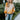 Close up view of model wearing the Autumn Skies Sweater which features light orange, bright orange and rust knit fabric, diagonal stripe pattern, round neckline with ribbed knit fabric and long ballon sleeves with ribbed knit fabric wrists.