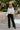 Full body view of model wearing the Always on Trend Blouse which features white speckled fabric, front and back smocked detailing, square neckline, lace hem detailing and long balloon sleeves with lace details and elastic ruffle wrists.