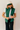 Front view of model wearing the Naya Hunter Green Athletic Vest which features green light weight puffer fabric, a thick hem, a monochromatic front zipper, two front pockets with zipper closures, a high neckline and a sleeveless design.