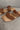 Close up view of the Beach by Matisse Amalia Flat Sandal in Tan which features light brown braided upper, two straps, slide-on style and flat sole. 