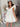 Front view of model wearing the Sweet Life Bubble Dress that features ivory satin fabric, mini length, a bubble hem, a round neckline, ruffle straps and a monochromatic back zipper with a hook closure.