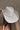 Back view of model wearing the Lainey Ivory Rhinestone String Cowgirl Hat which features cowboy shape, ivory suede fabric and rhinestone covered adjustable string.