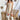 Full front view of model wearing the Desert Sands Skirt that has natural colored fabric, an open knit crochet design, natural colored lining, mini length, and a drawstring tie with tassel details at the waistband