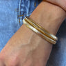 Front view of model wearing the Some Kind of Love Bracelet Set which features two layered, gold thick stretchy bracelet.