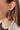 Side view of model wearing the O Christmas Tree Earrings which features an embellished red truck with a tree. 