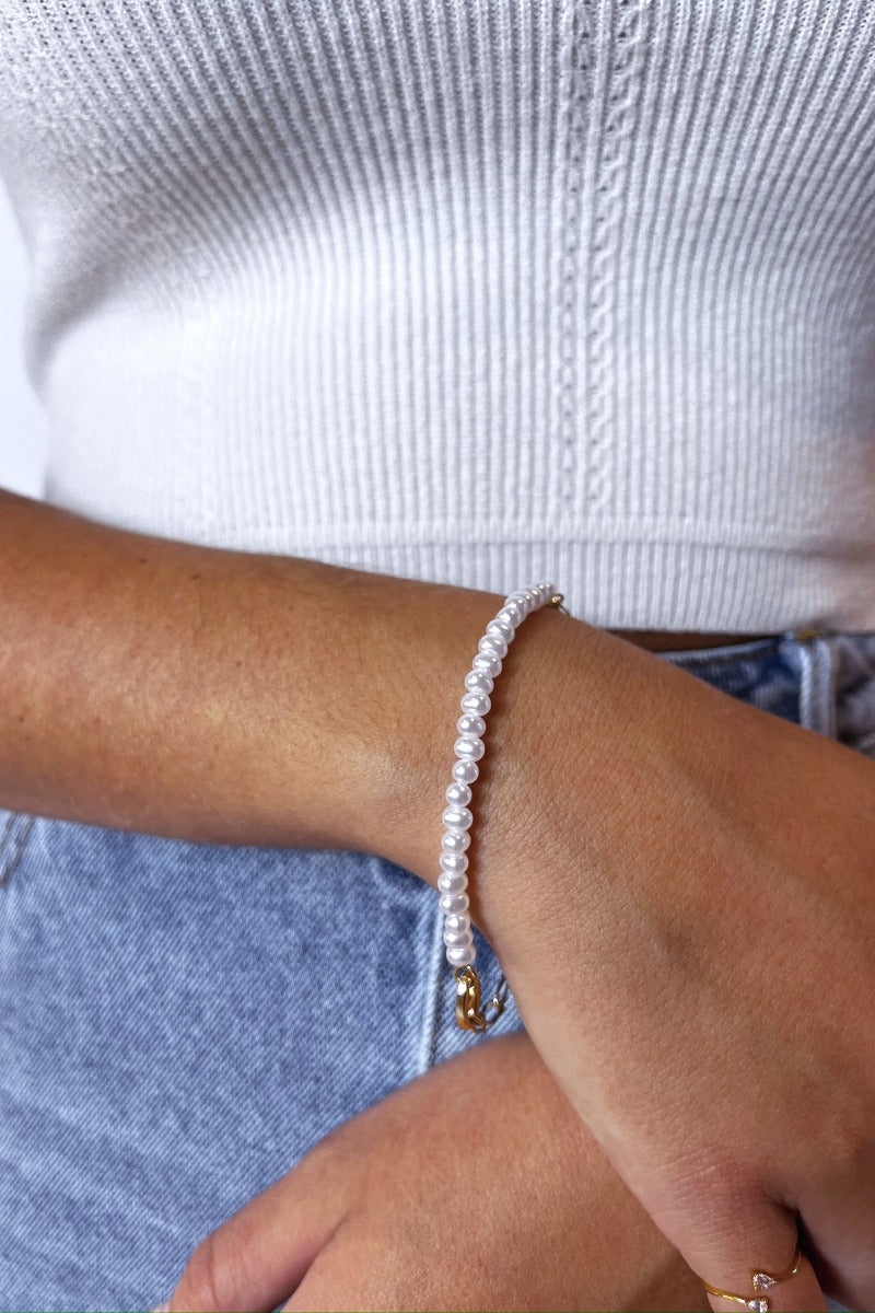 Front view of model wearing the In Love Pearl Bracelet which features pearls linked with a gold chain design.