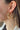 Side view of model wearing the Full of Jazz Earrings which features topaz large jewels on gold hoops. 