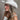 Side view of model wearing the Lainey Ivory Rhinestone String Cowgirl Hat which features cowboy shape, ivory suede fabric and rhinestone covered adjustable string.