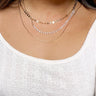 Front view of model wearing the I Want You Back Necklace which features three-layered necklace, first layer has clear and gold beads, second layer has small gold medallions and third layer is a flat gold layer.