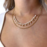 Front view of model wearing the Be There For You Necklace which features double-layered gold chain link with two-tone cream beads.