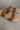Close up view of the Beach by Matisse Amalia Flat Sandal in Tan which features light brown braided upper, two straps, slide-on style and flat sole. 