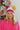 Front view of model wearing the Stay Cozy Beanie in Beige, that features beige sherpa fabric, pink cable knit trim, and a yellow pom pom.