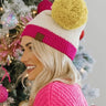 Side view of model wearing the Stay Cozy Beanie in Beige, that features beige sherpa fabric, pink cable knit trim, and a yellow pom pom.