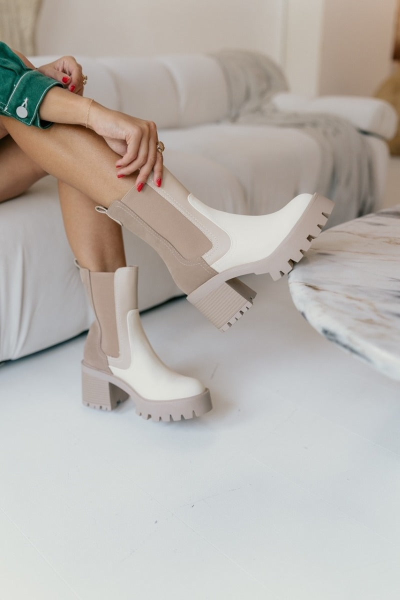 Close up view of model wearing the Remi Boot in Beige and Bone which features platform lug sole, pull tabs, two-tone style, mid-calf shaft height and stretch sides for easy fit.