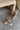 Flat lay view of model wearing the Risky Boot in Dark Taupe which features dark taupe suede fabric, chunky lug platform sole, back pull tab, round toe and inside side monochrome zipper.