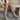 Front view of model wearing the Risky Boot in Dark Taupe which features dark taupe suede fabric, chunky lug platform sole, back pull tab, round toe and inside side monochrome zipper.