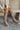 Front view of model wearing the Risky Boot in Dark Taupe which features dark taupe suede fabric, chunky lug platform sole, back pull tab, round toe and inside side monochrome zipper.