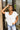 Frontal view of the Got Your Back Top that features a white gauze material, straight neckline, a short ruffle sleeve, frayed stitching details through out, and a flowy fit.